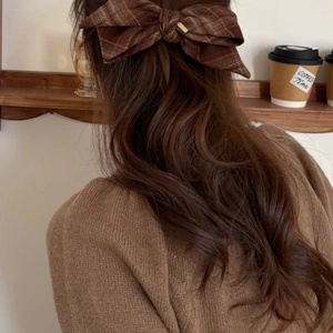 Detail of brown plaid bow hair clip on model back for an elegant vintage French style hair look