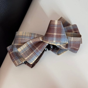Close-up of vintage British style plaid bow banana clip with detailed fabric texture