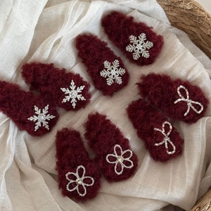 Detail of red plush hair clips with rhinestone snowflakes and flower decorations