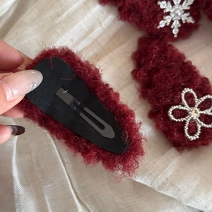 Detailed back view of a plush wine red flower hair clip with a black metal BB buckle