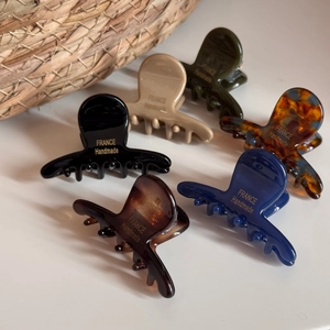 Détail de petites pinces à cheveux en acétate coloré avec l'inscription dorée France Handmade