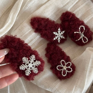 Detailed view of four burgundy plush hair clips featuring pearls and rhinestone accents