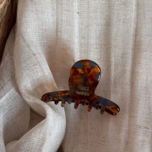 Détail de la pince à cheveux en acétate écaille avec lettrage doré France Handmade sur lin