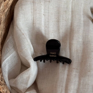 Gros plan sur la pince à cheveux en acétate noir avec lettrage France Handmade doré