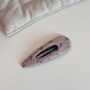 Nahaufnahme der Haarspange aus Wollstoff mit schwarzen Schleifenmustern und BB-Metallclip