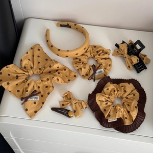Vue détaillée des accessoires cheveux à pois jaunes, incluant chouchous et barrettes