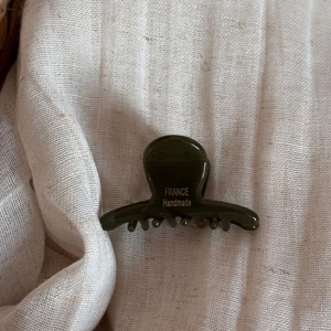 Vue détaillée de la petite pince à cheveux verte en acétate avec texte doré France