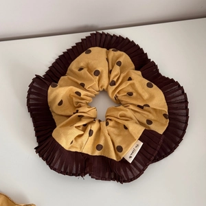Détail du chouchou jaune à pois avec bordure plissée marron et texture douce