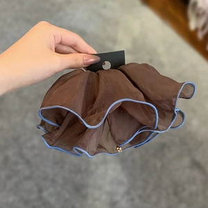 Brown mesh scrunchie with blue wavy trim and golden bell detail on display card
