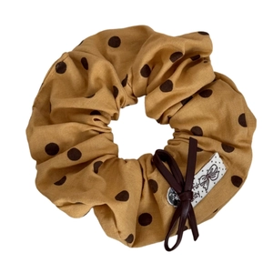 Chouchou jaune à pois marrons avec un petit nœud en cuir et étiquette blanche