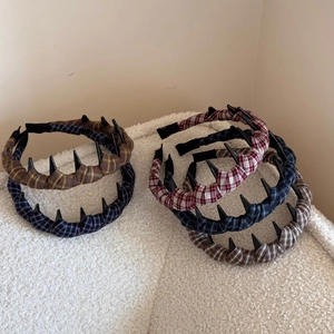 Plaid fabric headband with small black hair clips for styling on white fleece background
