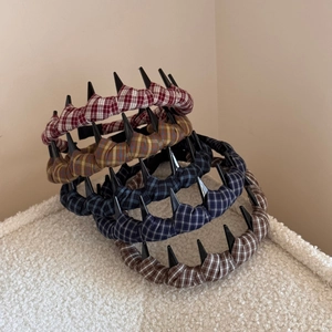 Detail of plaid fabric headbands with punk black rivet studs in various vintage colors