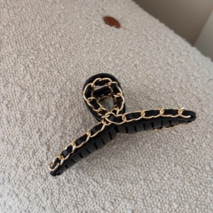 Close-up of black leather and gold chain braided hair claw clip with anti-slip teeth