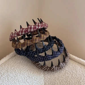 Detailed view of plaid headbands with decorative teeth design in various checkered patterns
