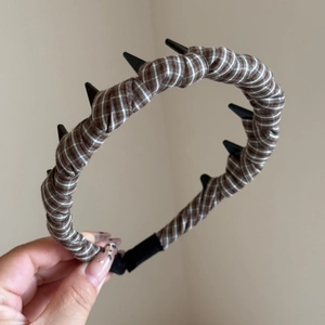 Detail of plaid fabric headband featuring inner teeth combs for a high cranium look