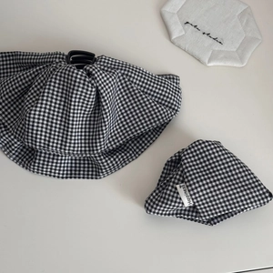 Close-up detail of black and white checkered fabric scrunchies with Happiness woven label