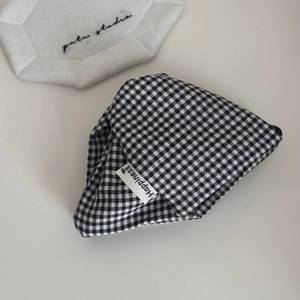 Close-up of black and white gingham fabric scrunchie with Happiness woven label detail