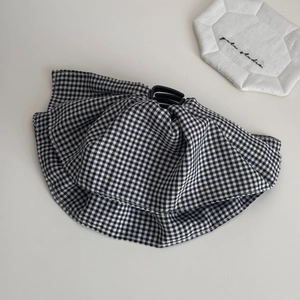 Detailed view of black and white plaid fabric scrunchie with elegant ruffled design