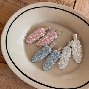 Set of 6 rhinestone duckbill hair clips in pink and blue on a ceramic tray
