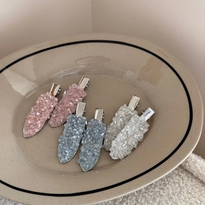 Detail view of 6 crystal duckbill hair clips with crushed ice texture in a ceramic dish
