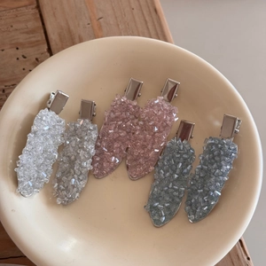Detail view of crystal rhinestone duckbill hair clips in silver, pink and blue colors