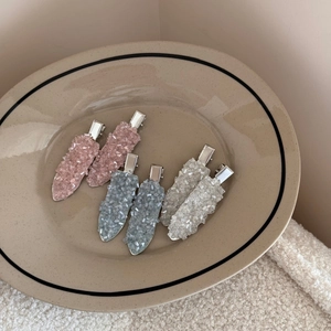 Close-up of six Korean style crystal hair clips in pink, blue, and clear colors