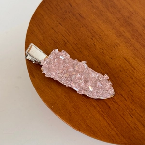 Detail of pink crystal hair clip with textured rhinestones and silver duckbill metal