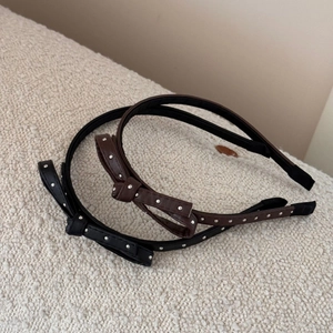 Chic thin leather headband with metallic polka dots and side bow in black and brown