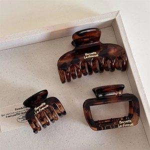 Three-piece tortoiseshell hair claw set with gold lettering on white fabric lining