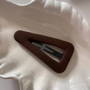 Détail montrant la texture velours marron foncé de la barrette BB triangulaire