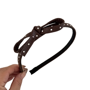 Brown leather polka dot bow headband with metallic studs for elegant hairstyling