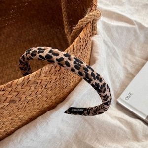 Detailed view of handmade fabric leopard print scrunchie with high elasticity and label