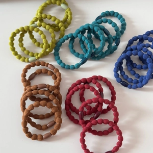 Dettaglio di elastici per capelli colorati con trama a onde in nylon e fibbie in plastica