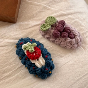 Détail macro de barrettes à cheveux faites main au crochet avec motifs fraise et raisin 3D