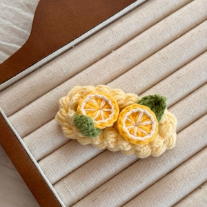 Macro d'une pince à cheveux citron au crochet faite main avec tranches jaunes et feuilles