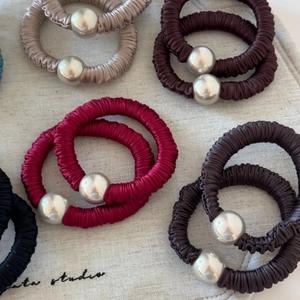 Detail of satin scrunchies with glossy finish and silver mirrored decorative beads