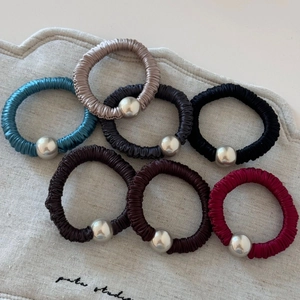Set of 7 colorful pleated silk scrunchies with silver bead accents on linen bag