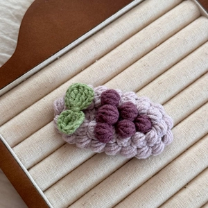 Vue détaillée d'une barrette à cheveux crochetée en forme de raisin violet faite main