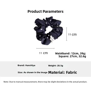 Detail view of navy blue polka dot scrunchie with 11cm diameter and elastic fabric texture