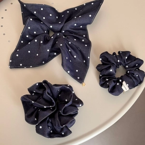 Detail of navy blue polka dot scrunchie set with handmade label and heart pendant