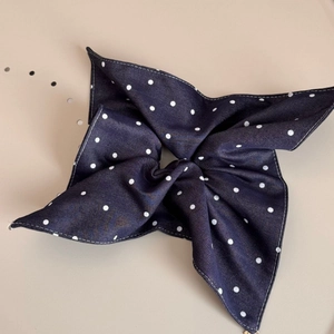 Detailed view of navy polka dot denim fabric hair scrunchie with bow structure