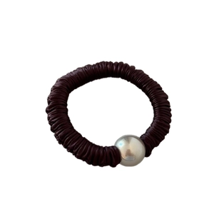 Elastic hair tie in dark brown pleated fabric featuring a polished silver metallic bead decor