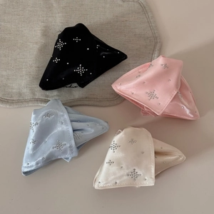Detailed view of four satin bow hair clips in black, pink, blue, and beige with star rhinestones