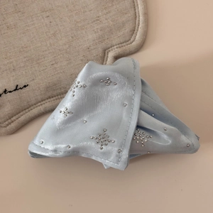 Detailed shot of light blue satin hair claw with sparkling cross star rhinestones decoration