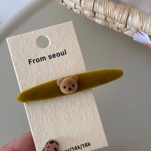 Detalle de una linda pinza para el cabello de oso flocado con base de terciopelo suave