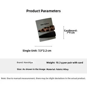 Detail showing two fashion hair clips in leopard and black fabric on a grey display card
