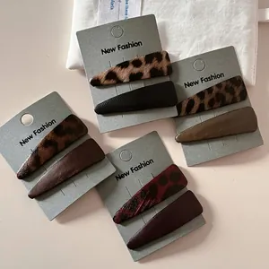 Set of leopard print and solid leather hair clips on a stylish decorative display