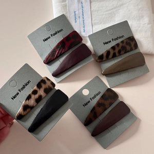 Detailed set of leopard print and solid faux leather triangle hair clips on display