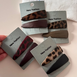 Close-up of leopard print leather triangle hair clips on retail cardboard packaging