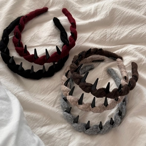 Détail d'un serre-tête tressé en maille avec clous noirs et dents antidérapantes de qualité